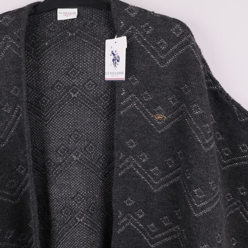 Detaljbild på poncho framtill samt hängande varumärkestagg