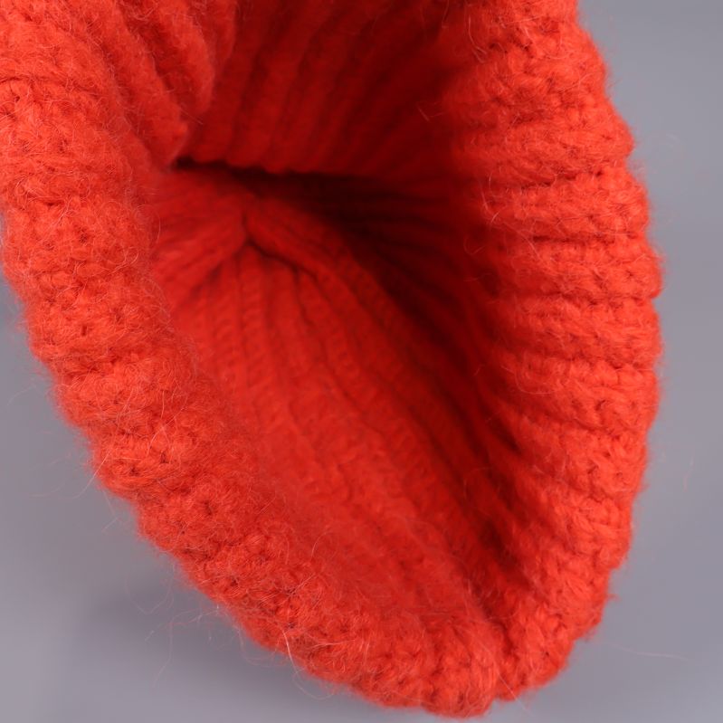 Insidan av orange ribbad stickad mössa uppvikt i närbild