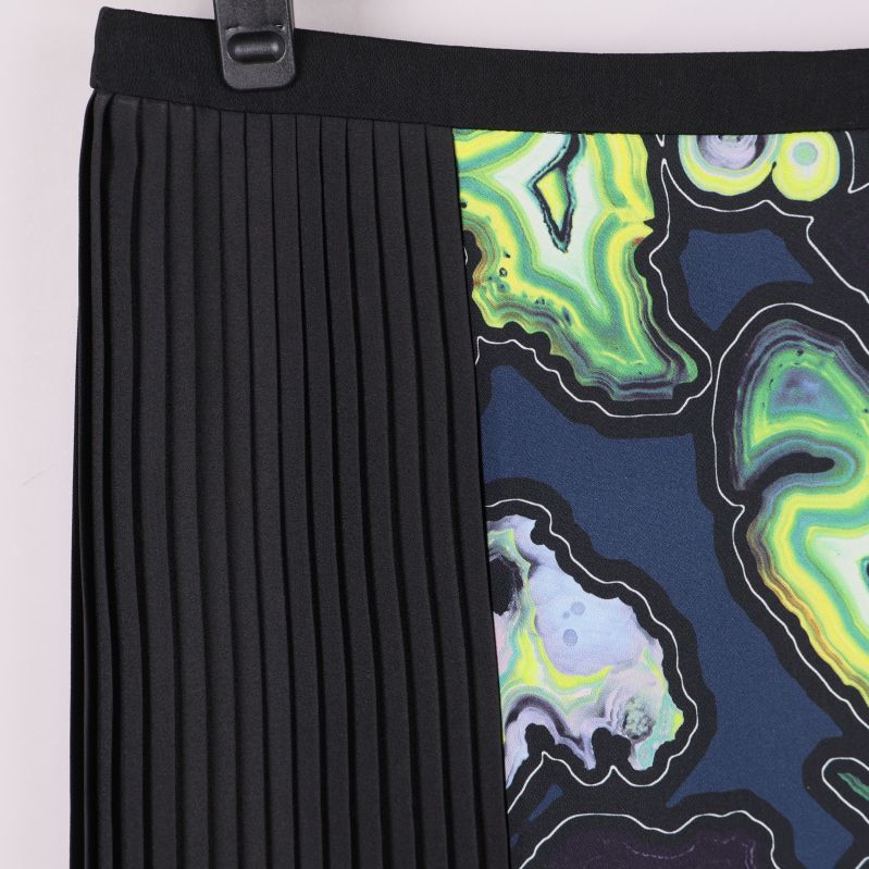 Detaljerad närbild på svart plissering och färgat mönster