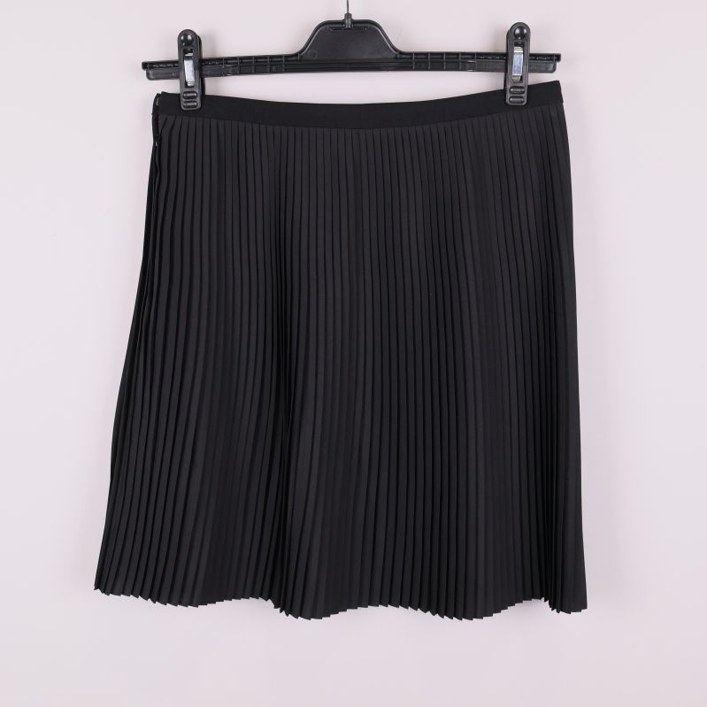 Baksidan på svart plisserad kjol