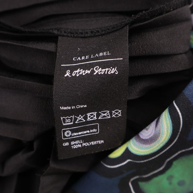 Tvättetikett som visar 100% polyester och skötselråd