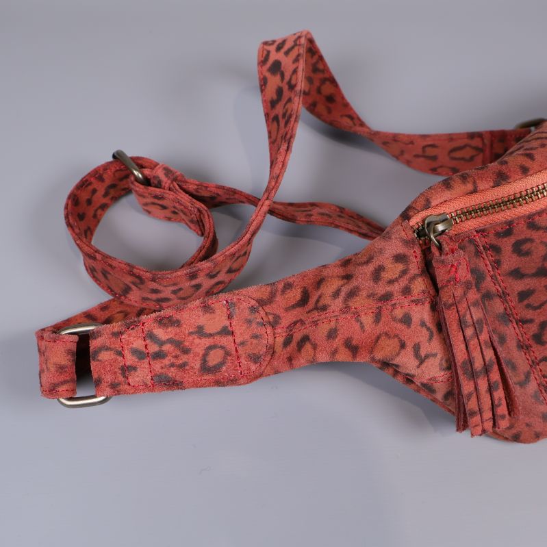 Närbild på justerbart spänne och band i leopardmönster