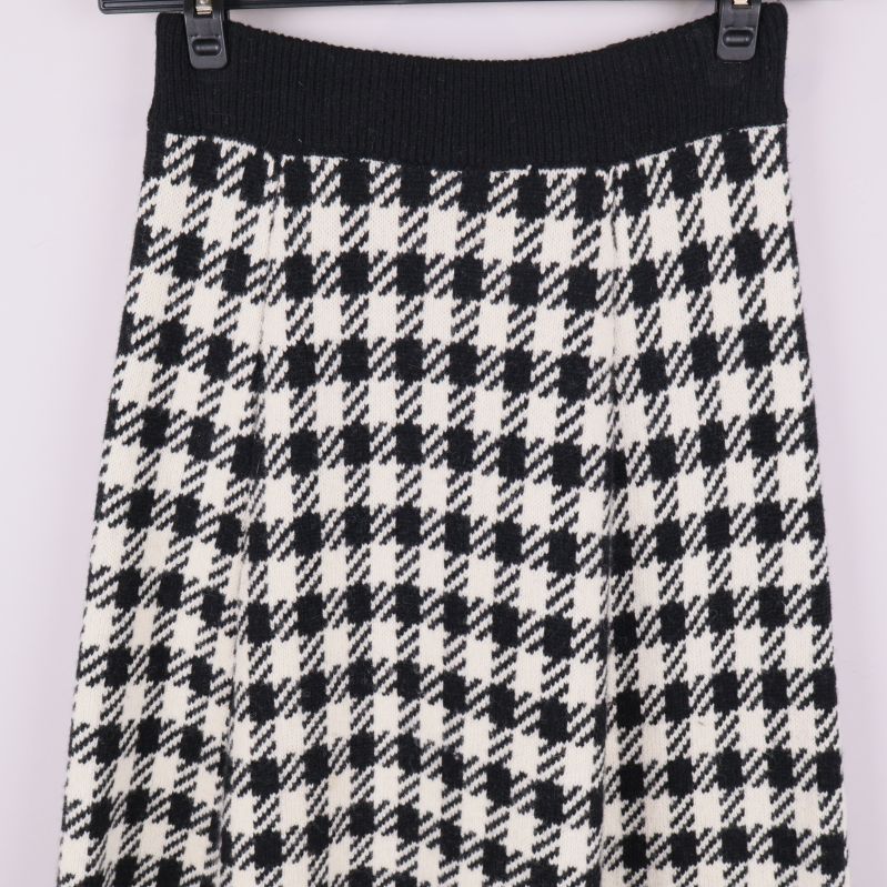 Närbild svartvit fiskbensmönstrad kjol vid midjan