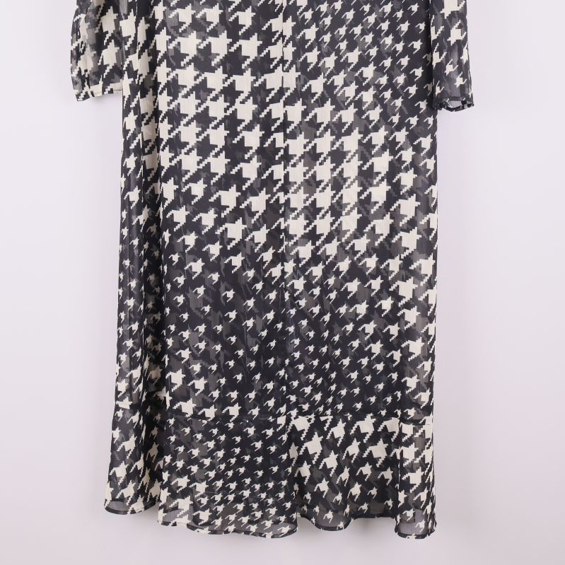 Nederdelen av svartvit långklänning med mönster