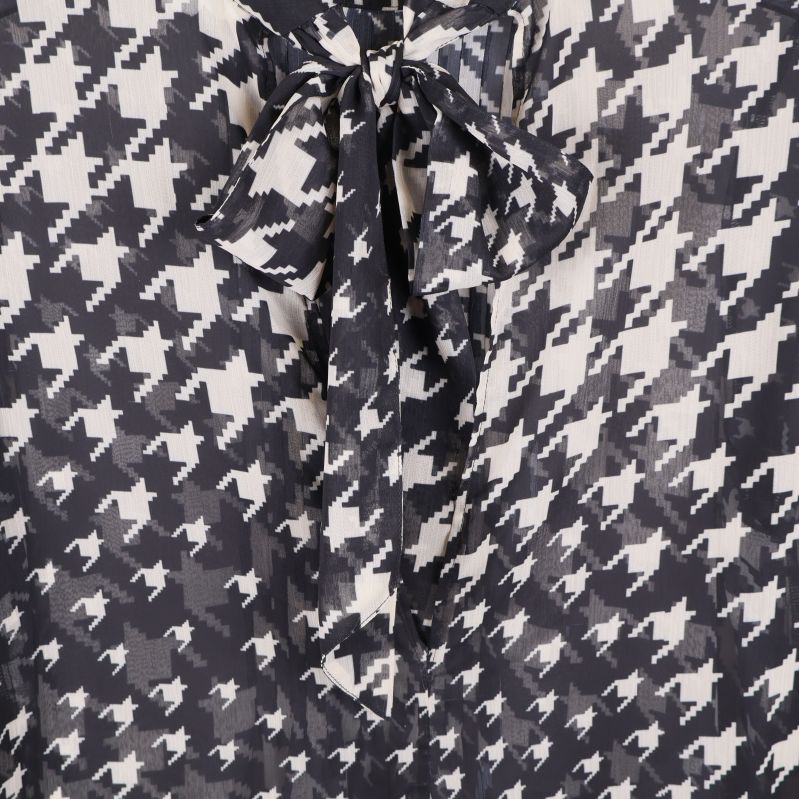 Närbild på knytband i halsen på klänning