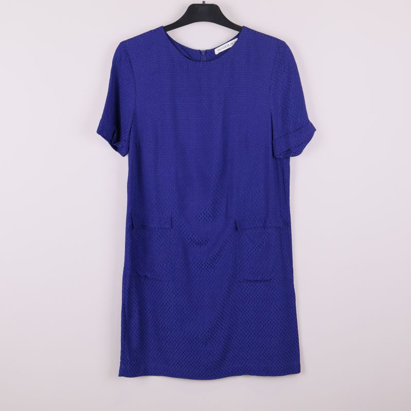 Framsida av blå strukturerad klänning på galge