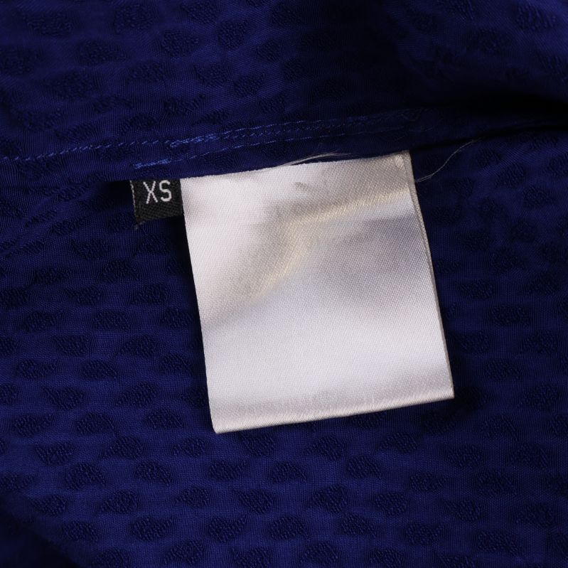 Storleksetikett med XS i svartvit på insidan