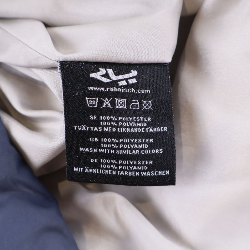 Materiallapp från jackans insida med information