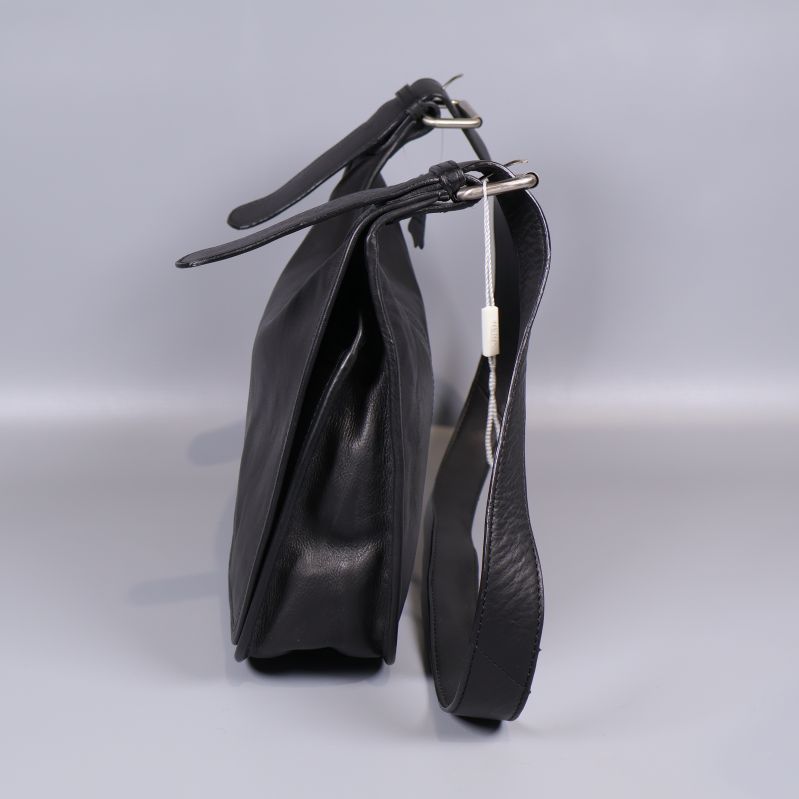 Svart väska fotograferad från sida med synlig rem