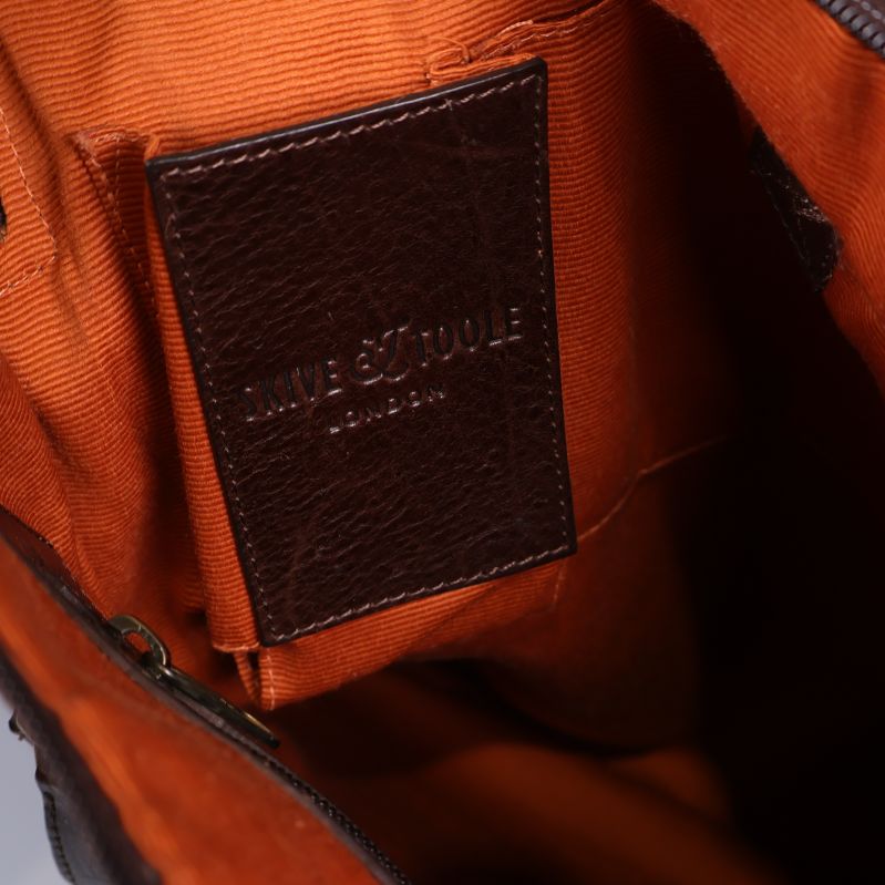 Närbild av läderetikett Knue & Toole London inuti väskan