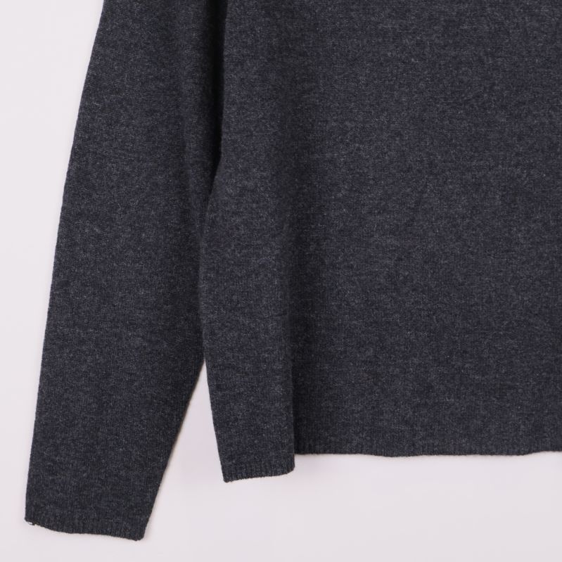 Närbild på ärmslut och nederkant av grå polotröja