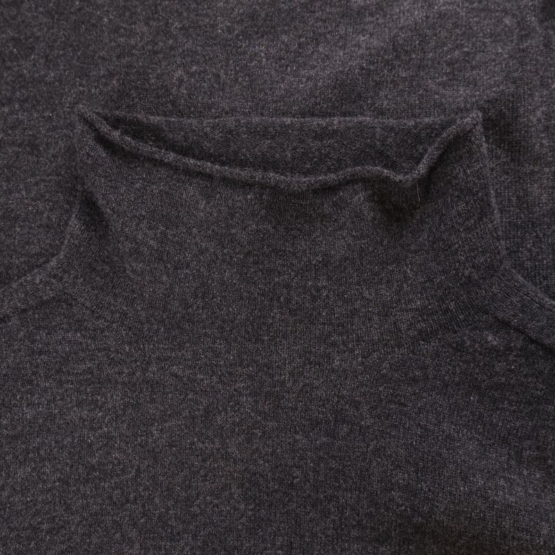 Närbild på uppvikt krage i stickat tyg