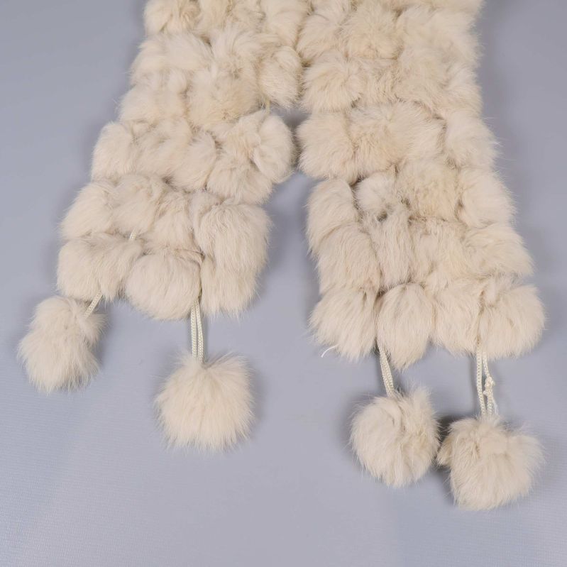 Närbild på tofsar i ändarna av halsduken