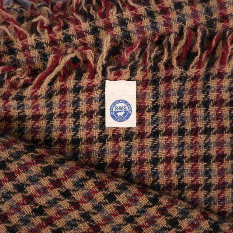 Etikett med blått tryck på halsdukens baksida