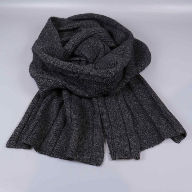 Stickad mörkgrå krage stylad liggande mot ljus bakgrund