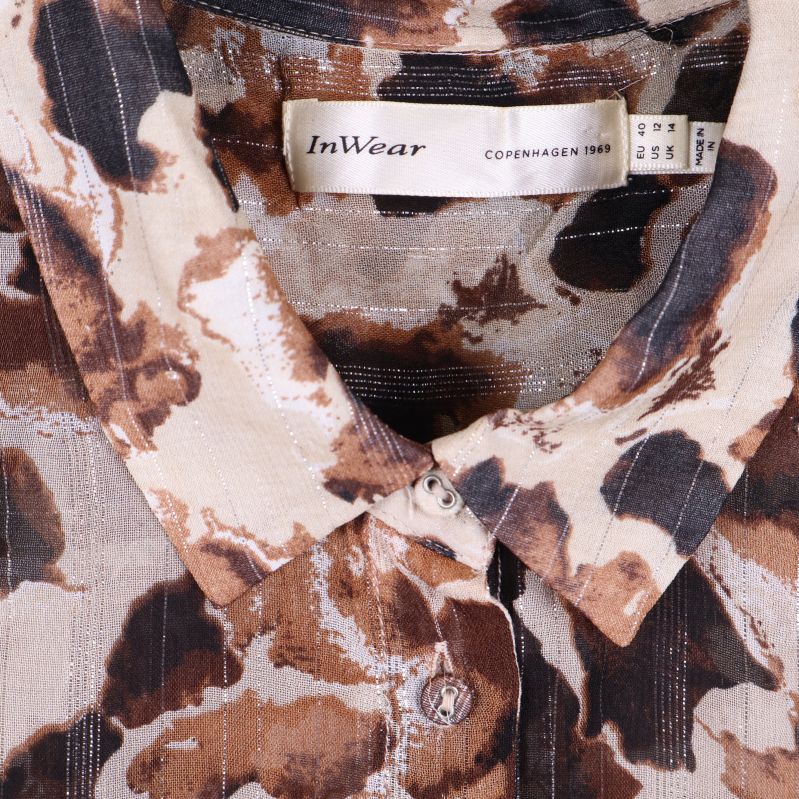 Närbild på krage och knäppning med märkesskylt