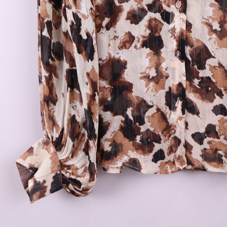 Närbild på ärmslut och tyg med blommigt mönster