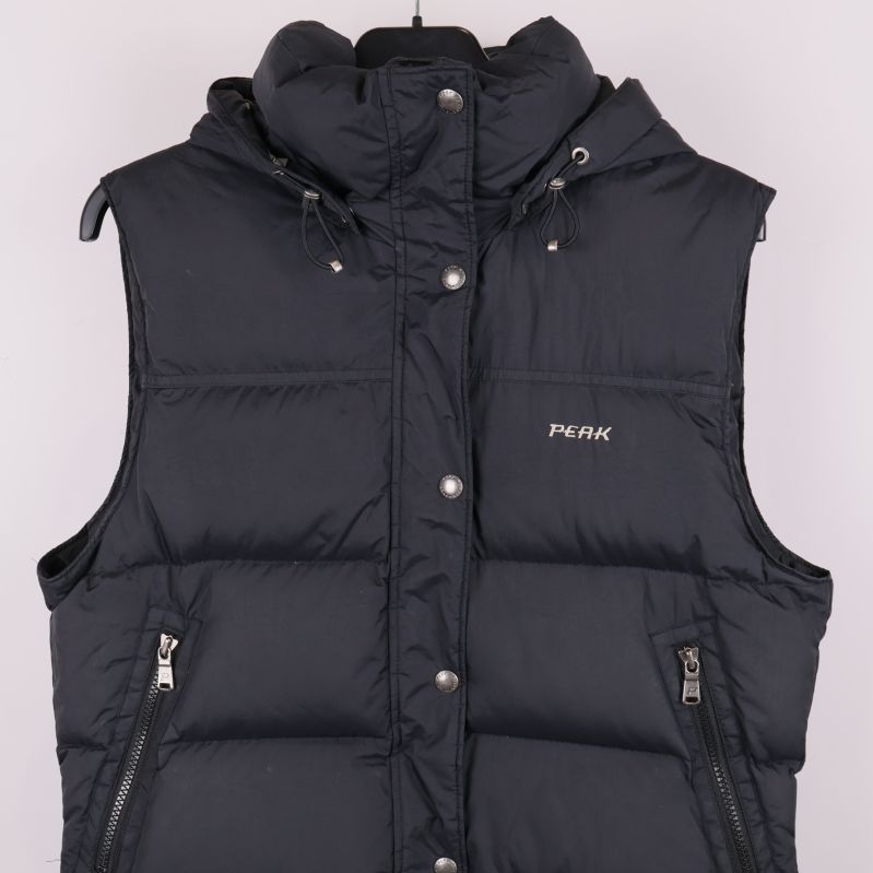 Framdetalj på mörk vadderad väst med tryckknappar