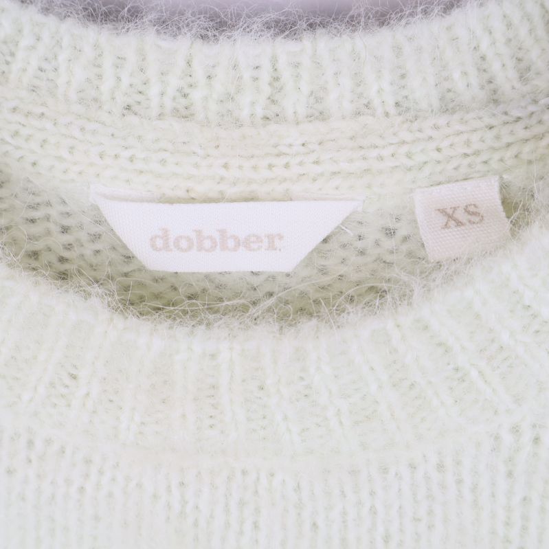 Dobber märkesskylt och storlekslapp XS i närbild