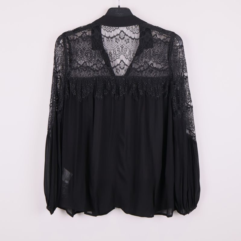 Baksida av svart blus med transparent spets