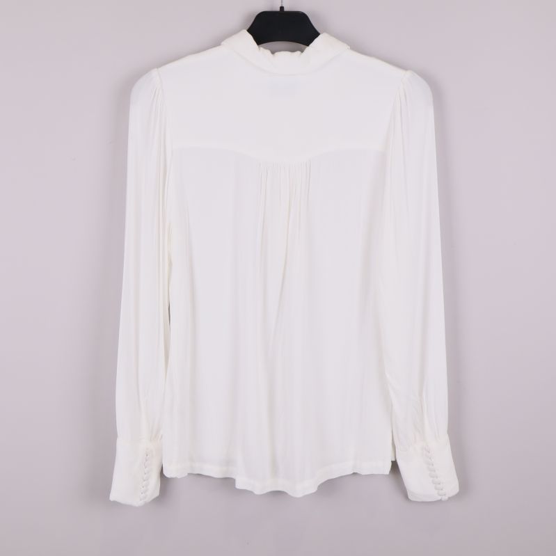 Baksida av vit blus med lätt rynkat ok