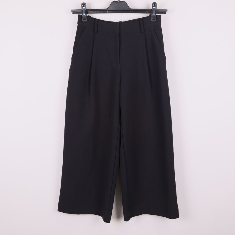 Framsidan av svarta vida kostymbyxor 