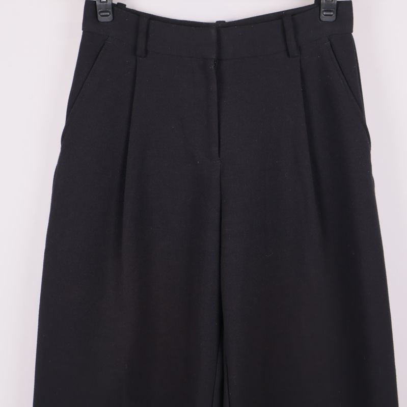 Framdelen av byxorna med synliga fickor och pressveck