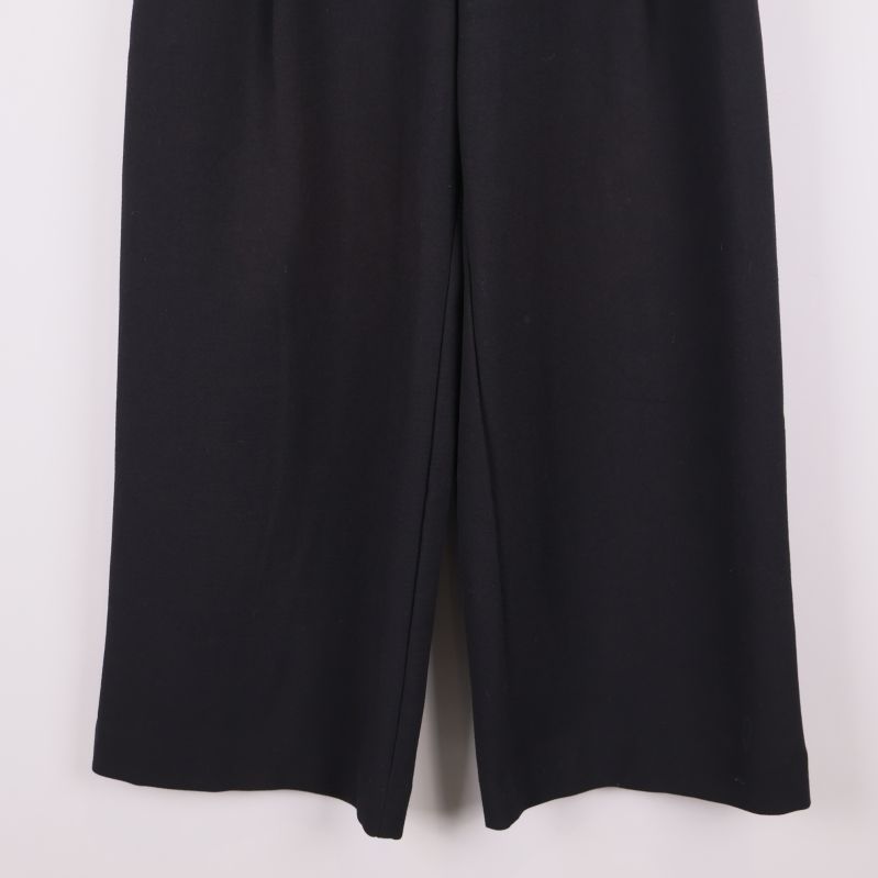 Nederdelen av vida svarta byxor och benslut