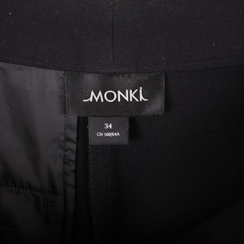 Närbild på Monki-etikett samt storlek 34 i byxorna