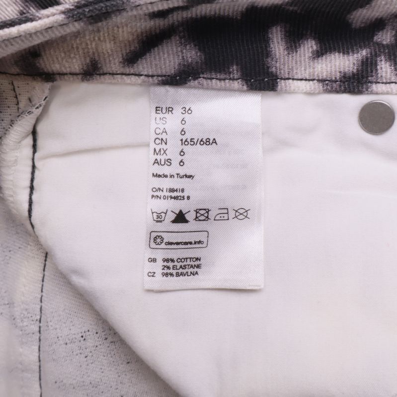 Material- och storleksetikett i svartvitrandiga byxor