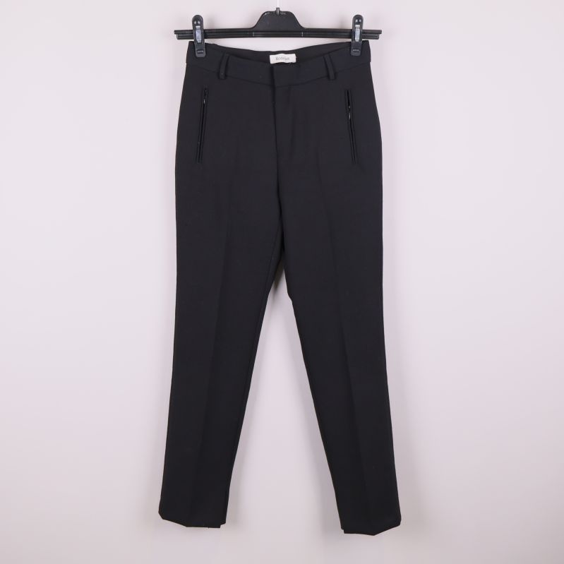 Svarta kostymbyxor på galge mot ljus bakgrund