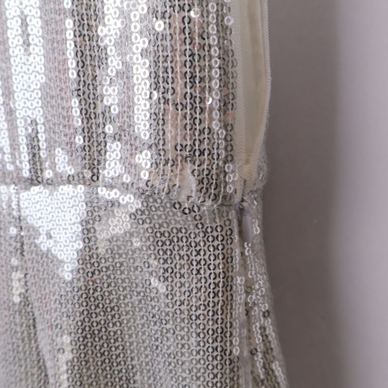 Sidsöm och paljettkant på vit klänning