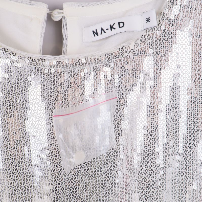 Närbild av NA-KD etikett vid halsen på klänning