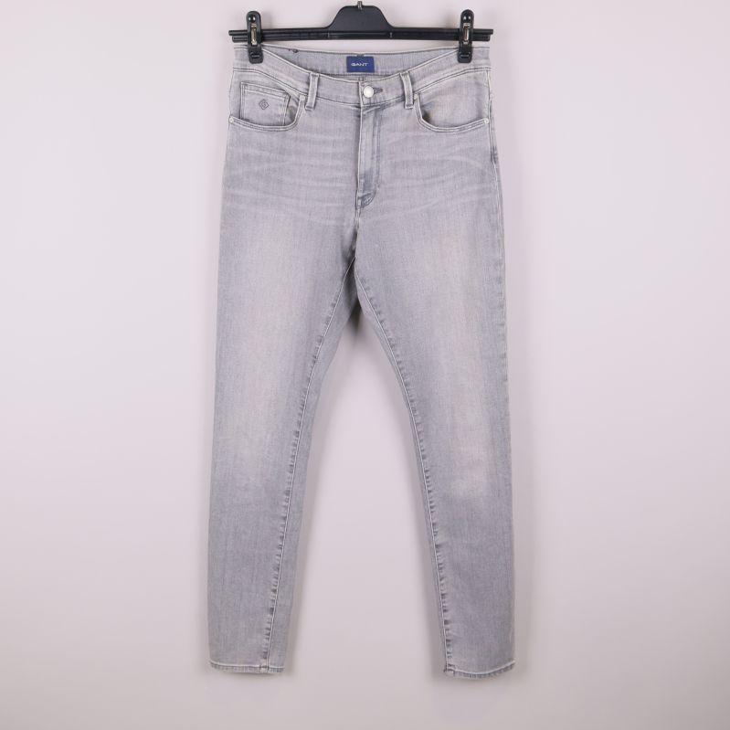 Framsidan av grå jeans 