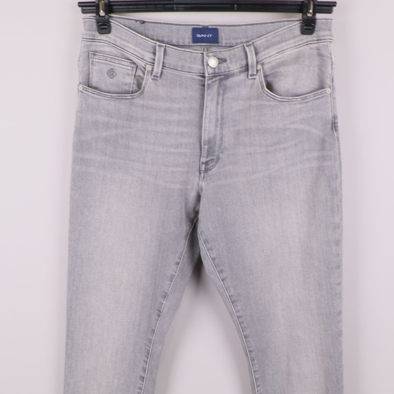 Midje- och fickdetaljer på grå jeans framifrån