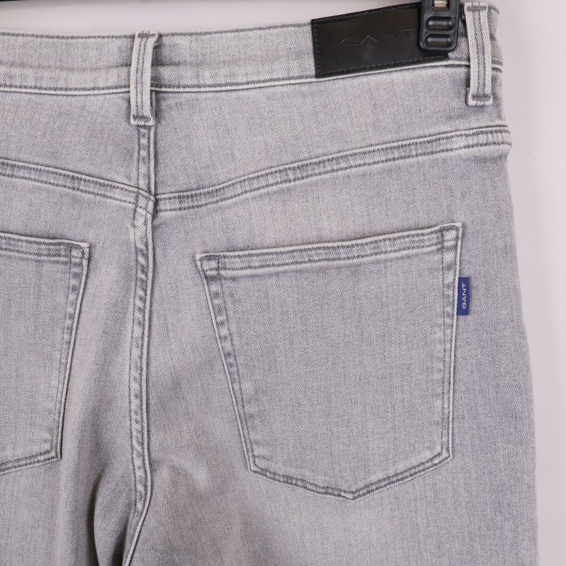 Närbild på bakfickor och blå Gant-etikett på jeans