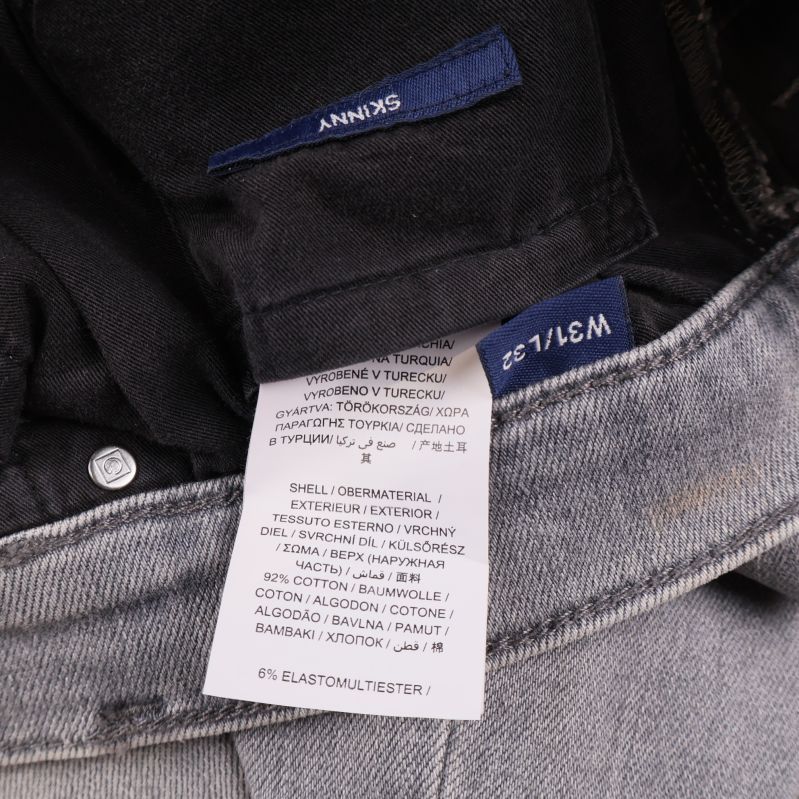 Materiallapp inuti grå jeans med materialinformation