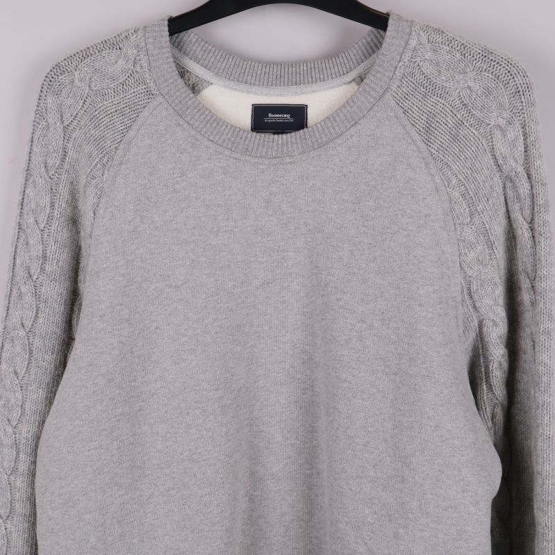 Närbild på tröjans övre fram och stickade ärmar