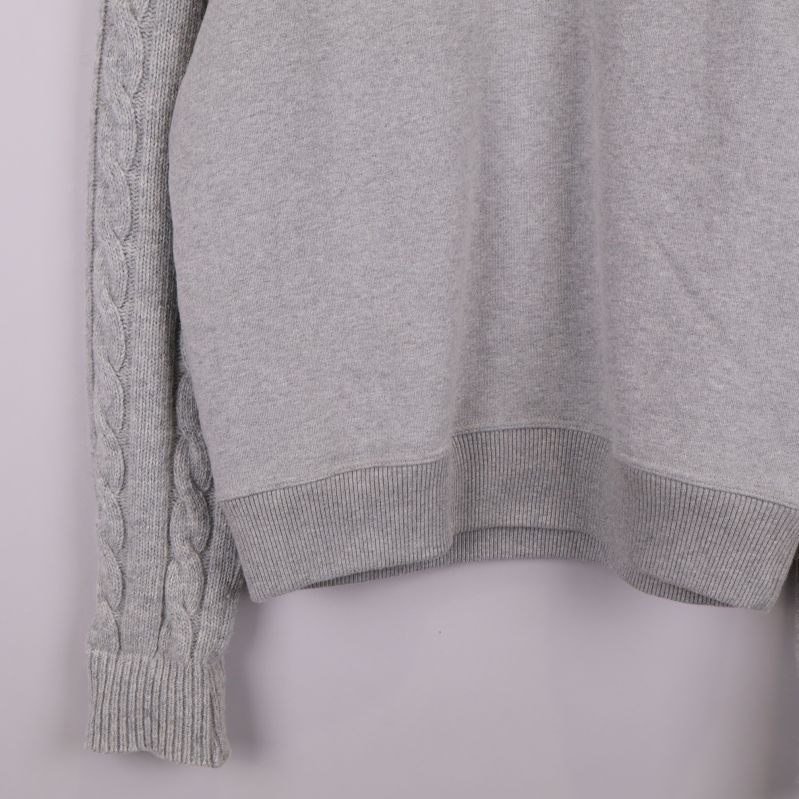 Närbild på tröjans nederkant och mudd i grått