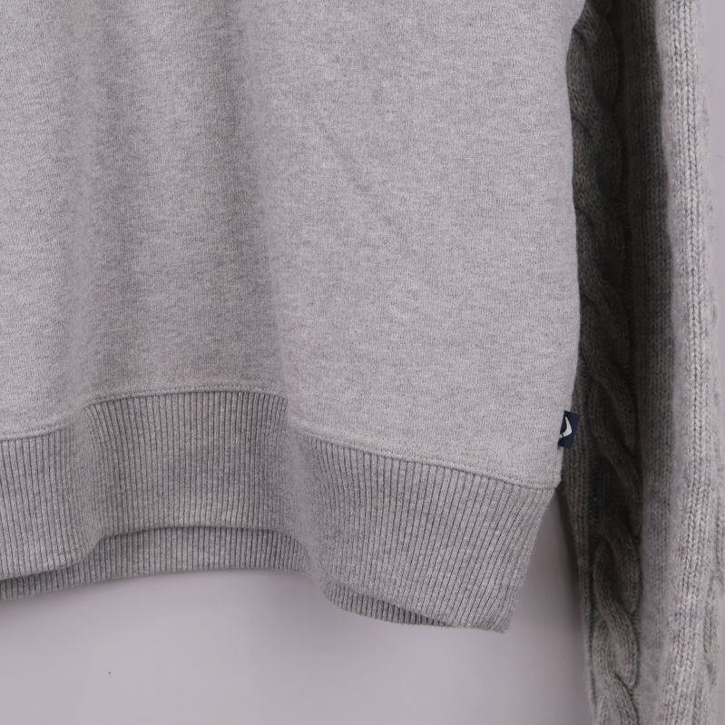 Närbild på ribbad söm längs nederdelen av tröjan