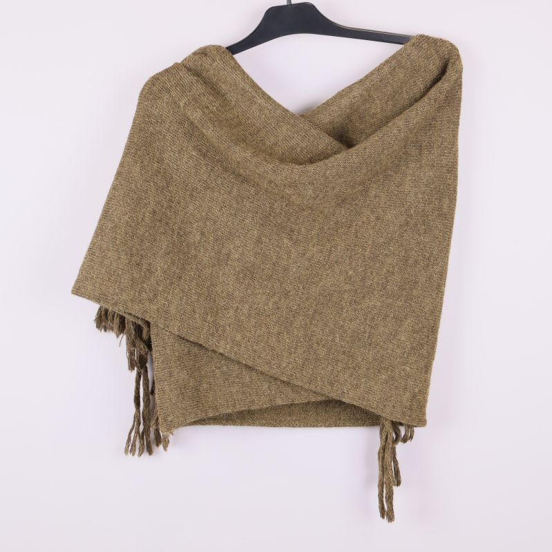 Baksida av brun stickad poncho hängande på galge