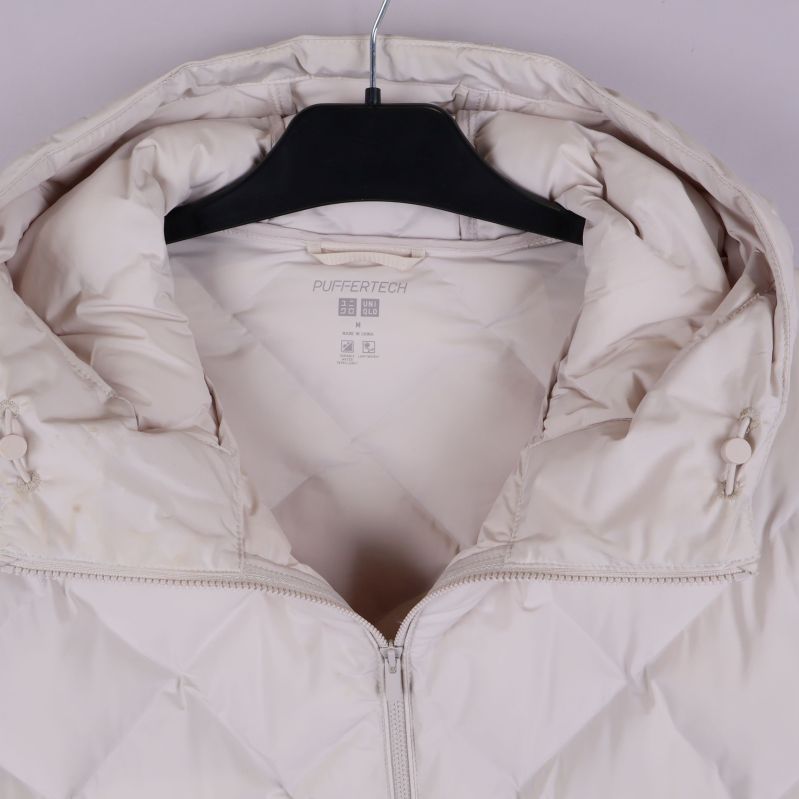 Närbild på huva och krage av quiltad jacka