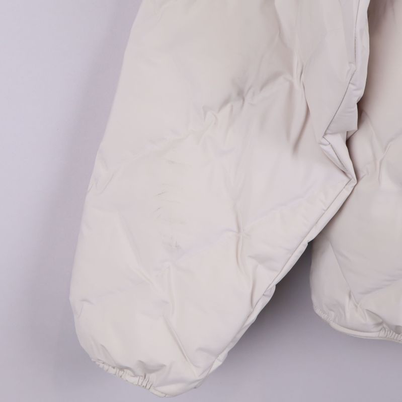 Närbild på nedre delen av ärmen på ljus jacka