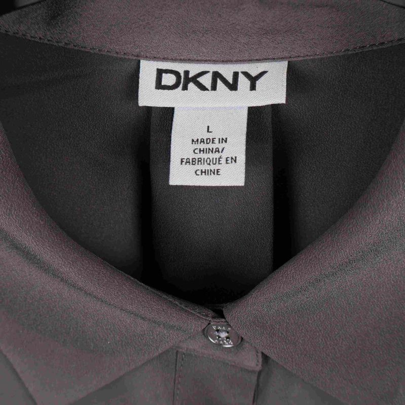 Närbild på DKNY-logotyp i nacken av skjorta