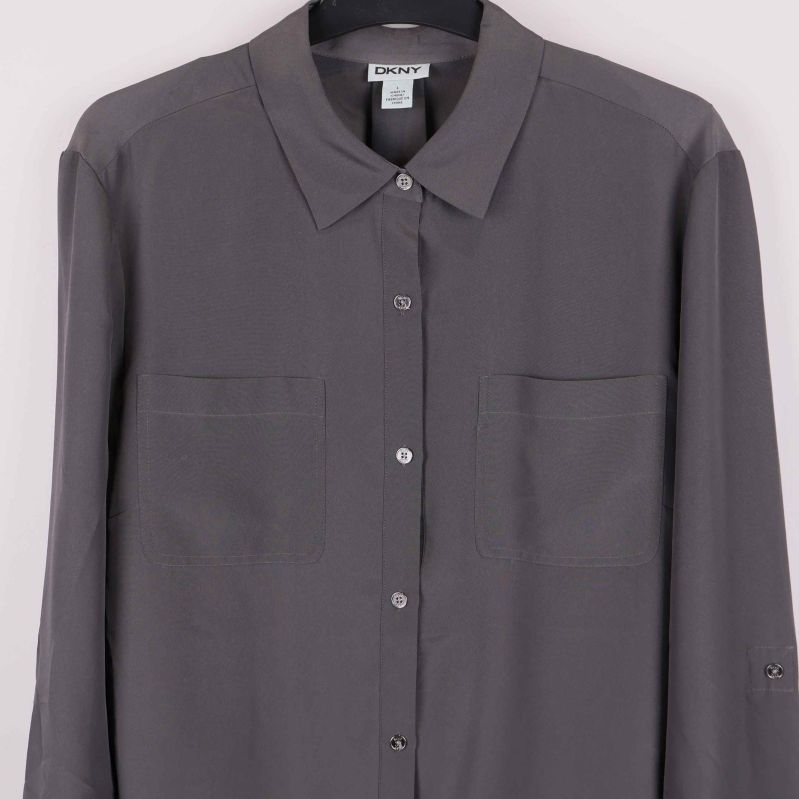 Närbild på skjortans knäppning och bröstfickor