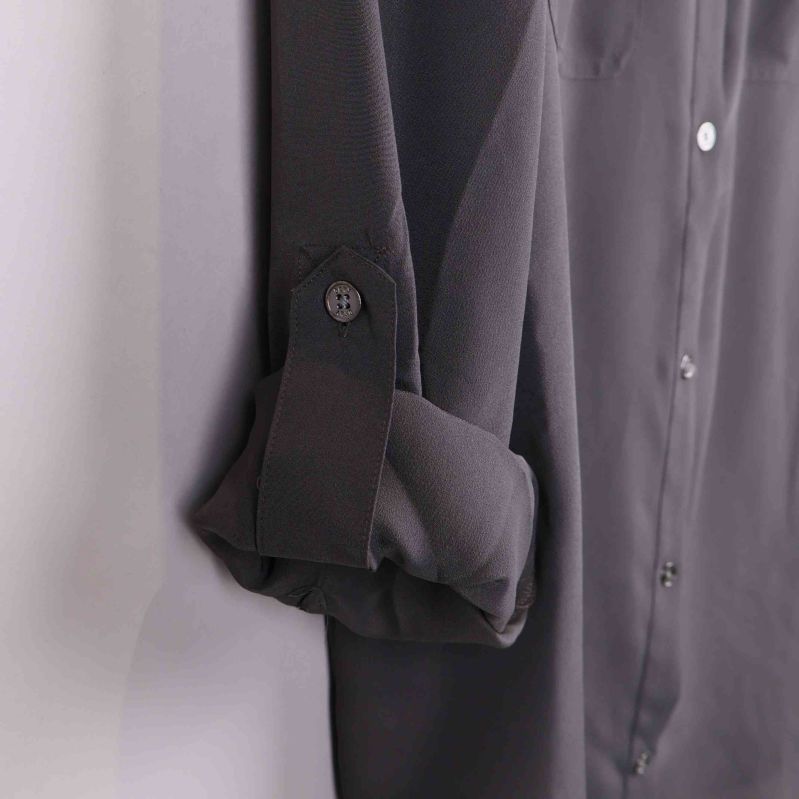 Ärm uppvikt och knäppt med knapp på grå skjorta