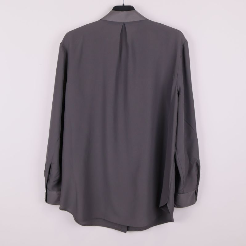 Baksida av grå skjorta med veck i ryggen