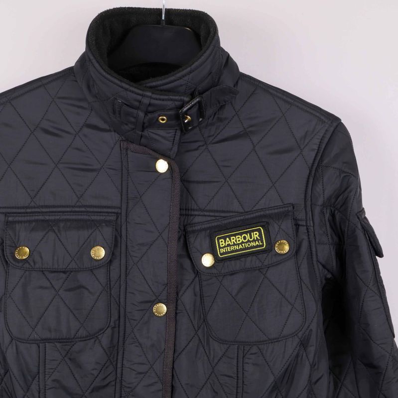 Ficka, etikett och krage i närbild på quiltad jacka