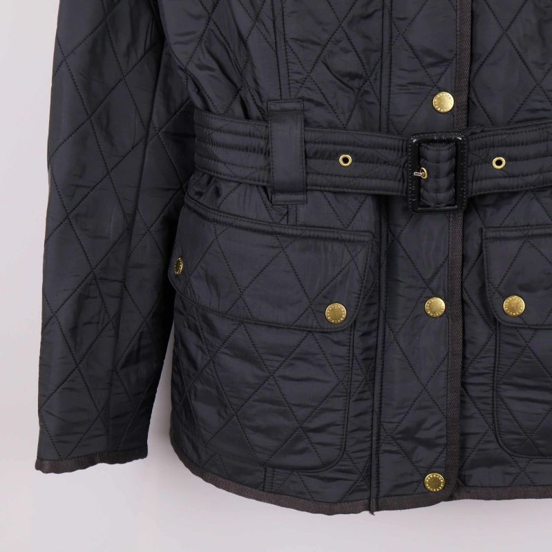 Nedre del av svart jacka med fickor och bälte