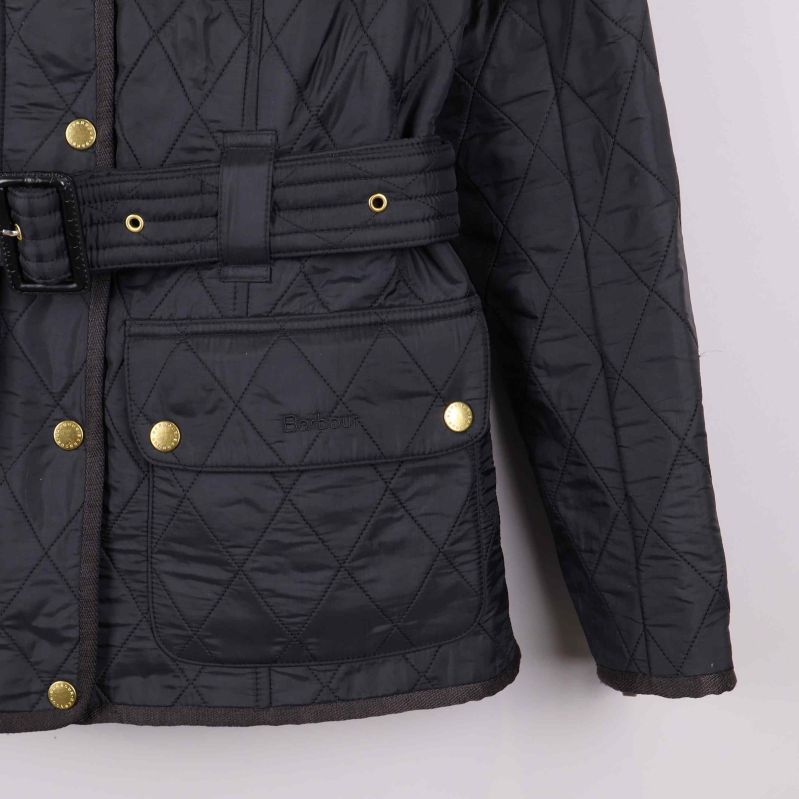 Ficka med guldknapp på nederdel av svart jacka